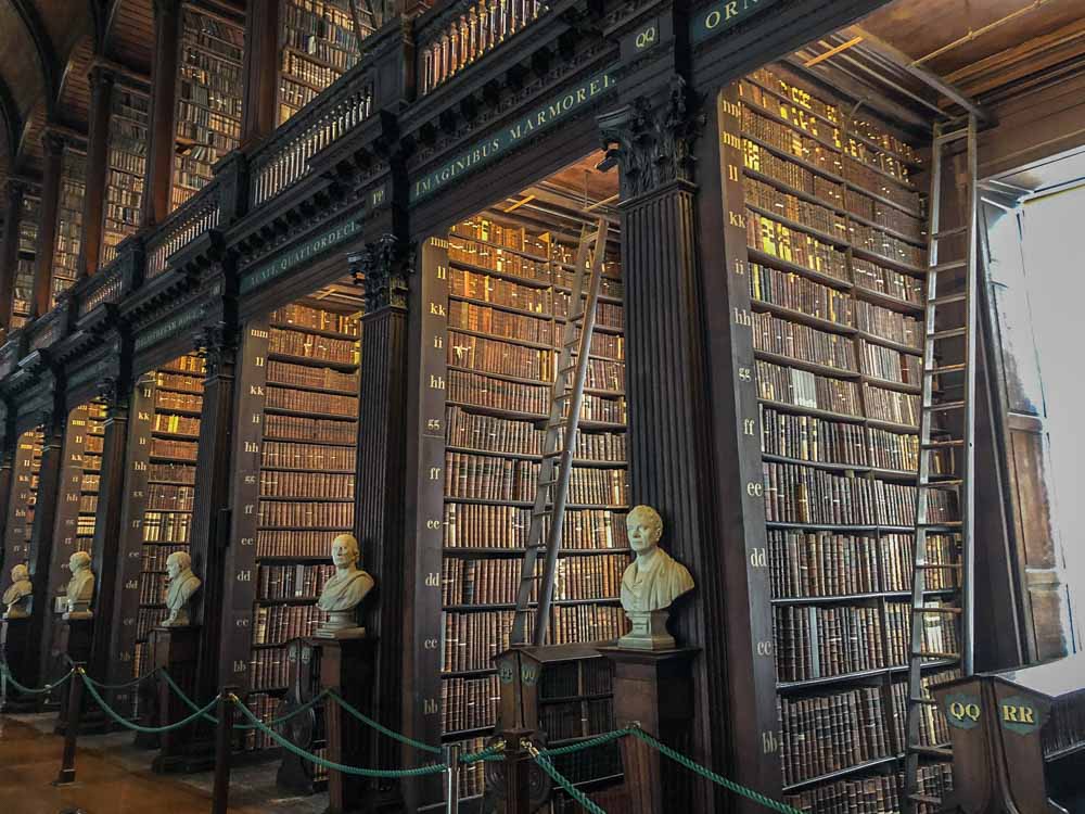 Dublin Ireland itinerary- Trinity College long library bookshelves with white statues