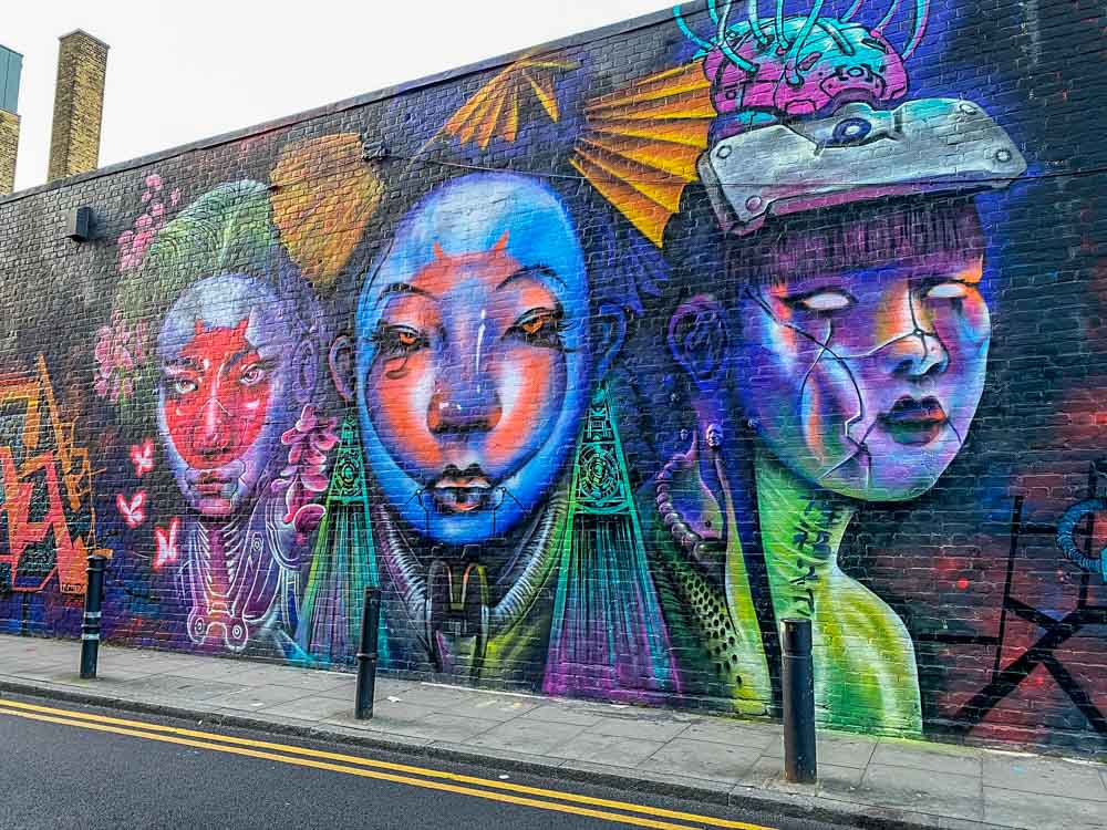 Shoreditch Brick Lane Mural on Hanbury St. Purple female figures