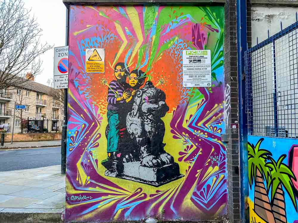 London Brick Lane mural Stinkfish. boy figures with a multi colored background