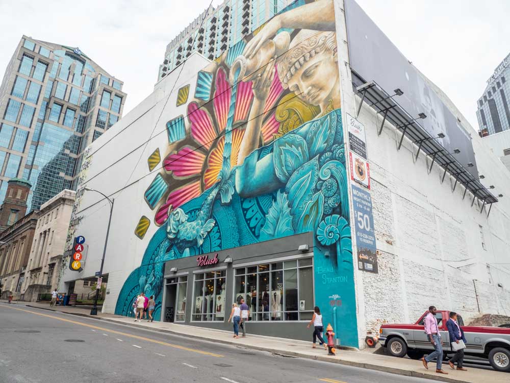 Beau Stanton mural - downtown nashville. Woman pouring water, pink and turquoise color