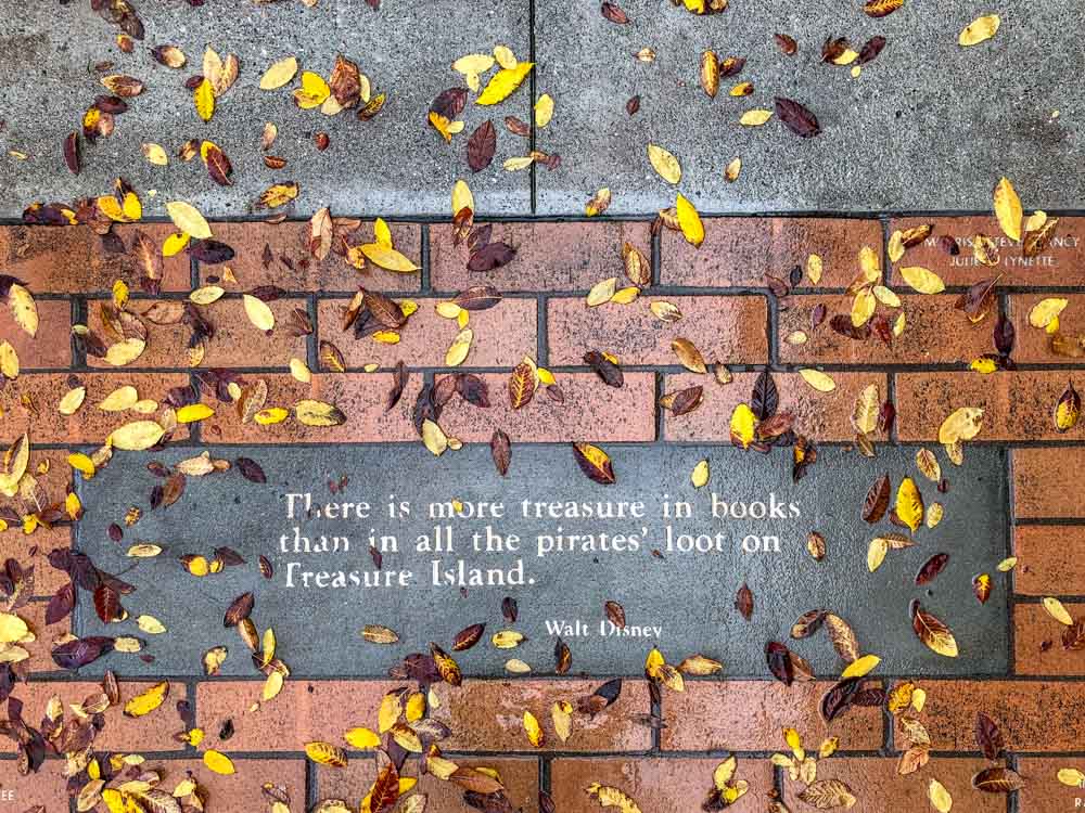 There is more treasure in books than in all the pirates' loot on Treasure Island. Walt Disney book quote. Leaves and brick.