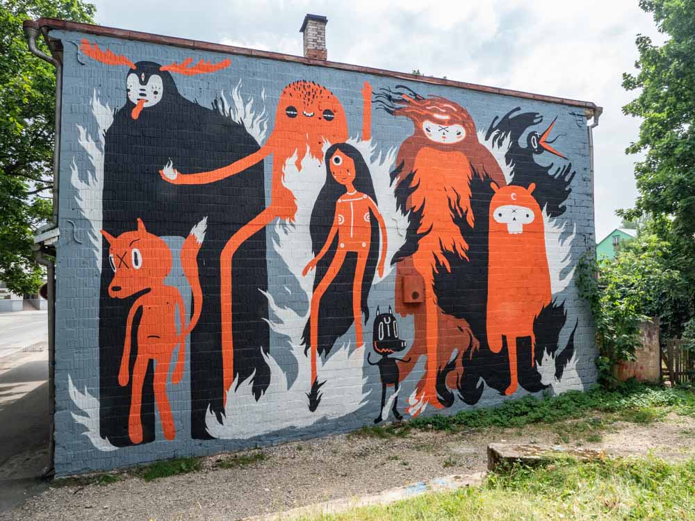 Tartu street art mural by KZRTE. black and orange folk characters