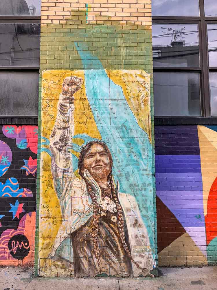 Brooklyn mural of Native American with fist raised by Lanopi
