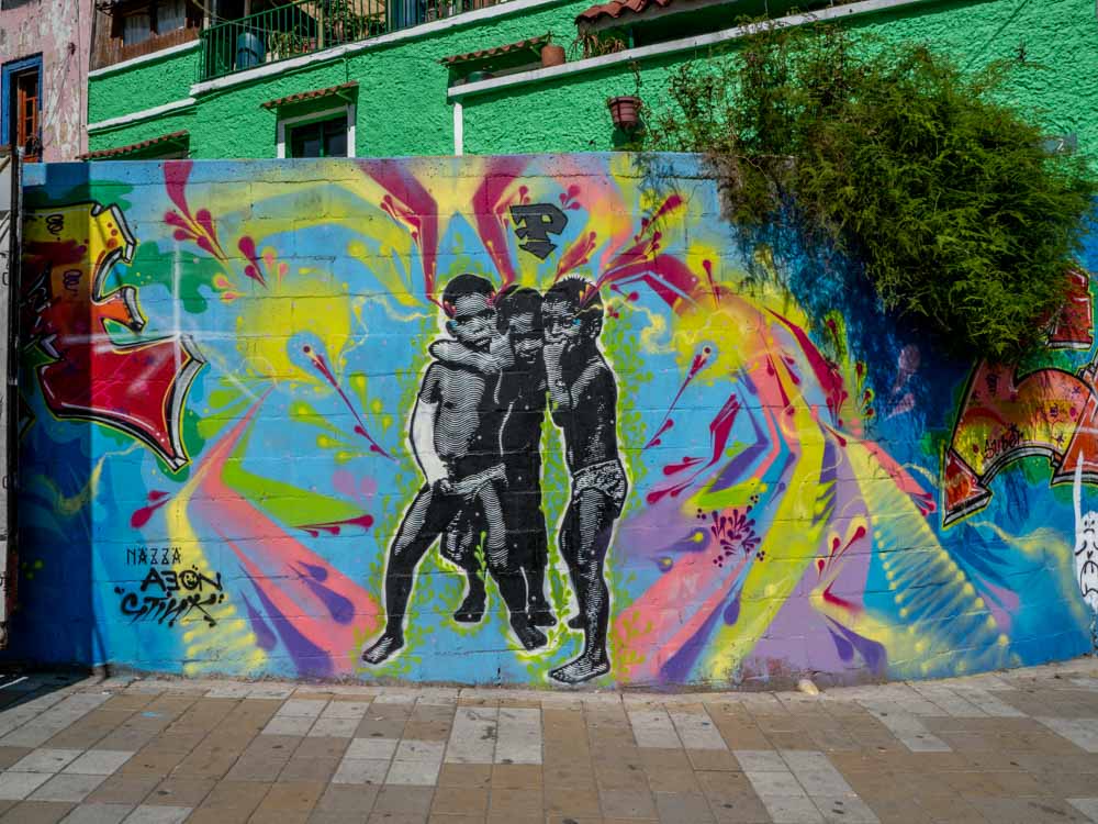 Street art Bogota- three boys by Nazza on multicolored background