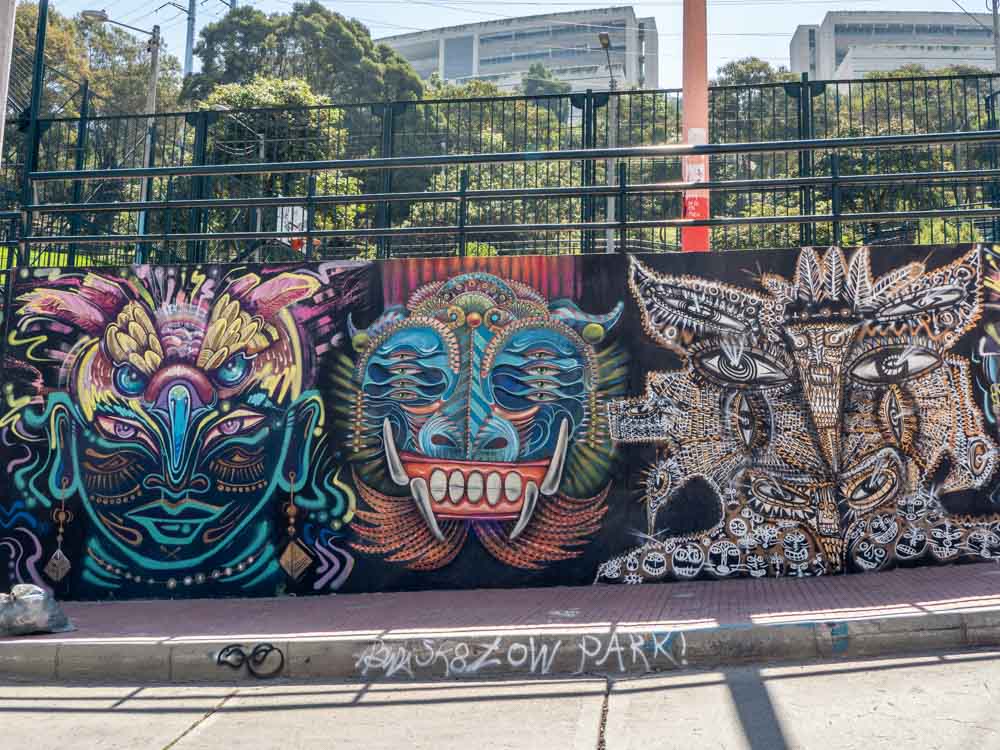 Bogota graffiti tour Parque la Concordia- mural on park wall with three masks