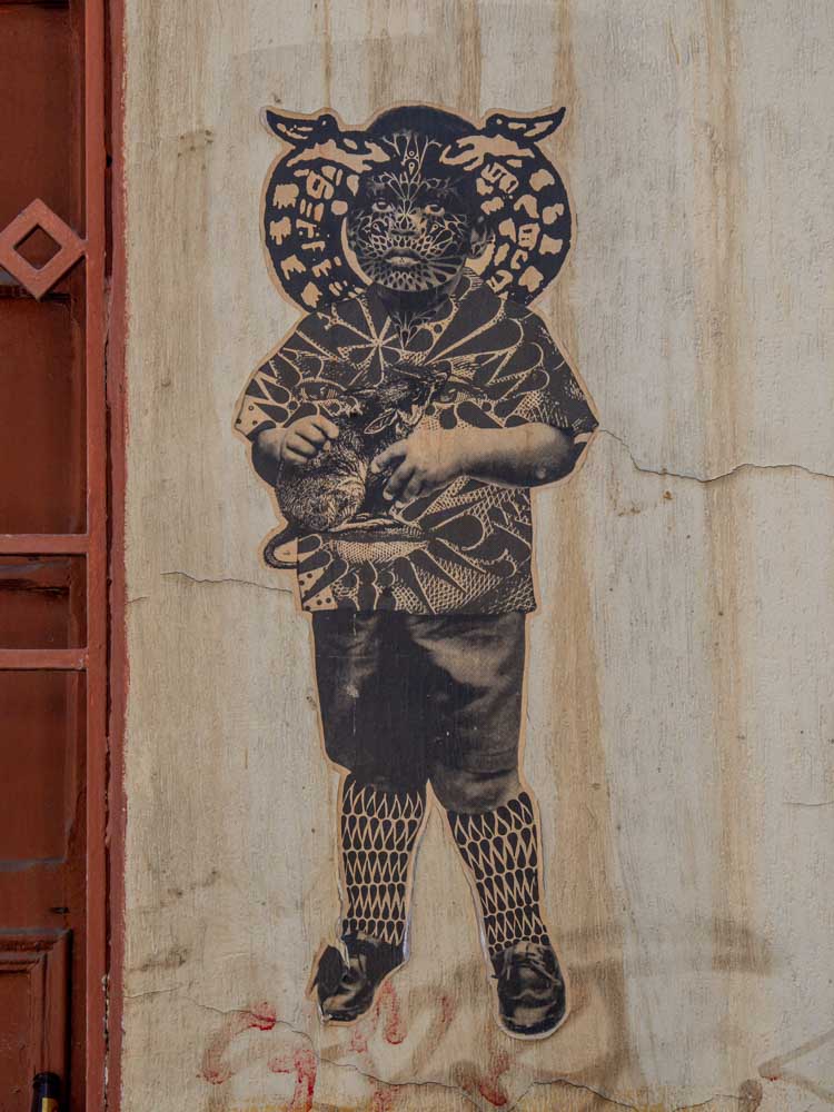 Sinkfish stencil in Bogota. Boy holding a rat