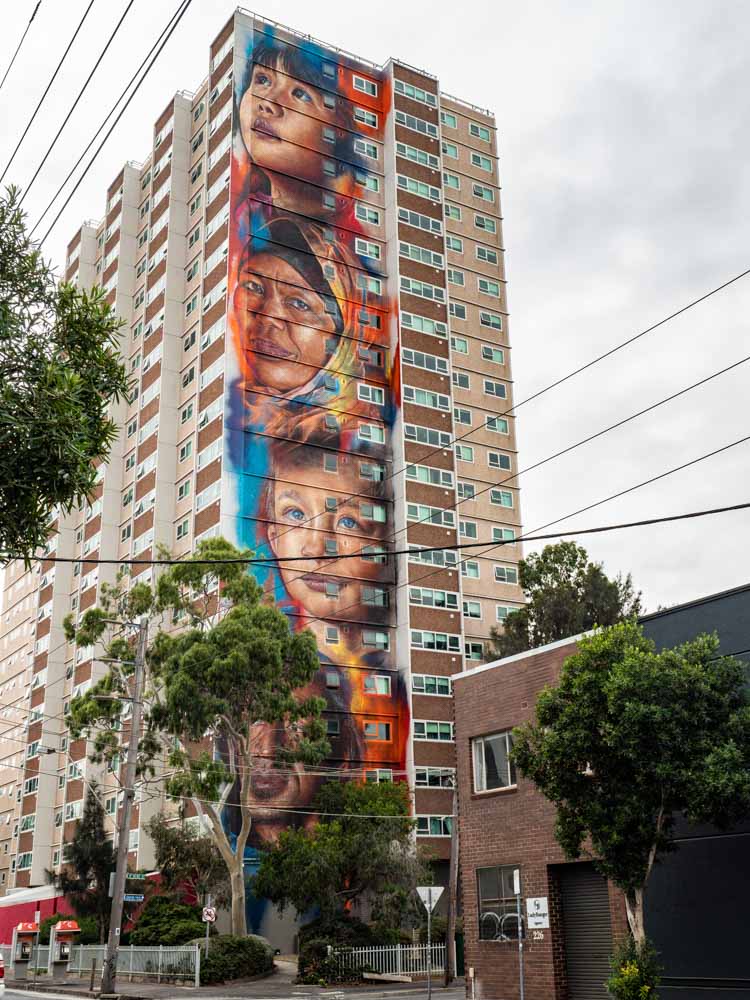 Melbourne mural by Adnate in Collingwood. Portraits of immigrants in blue and orange.