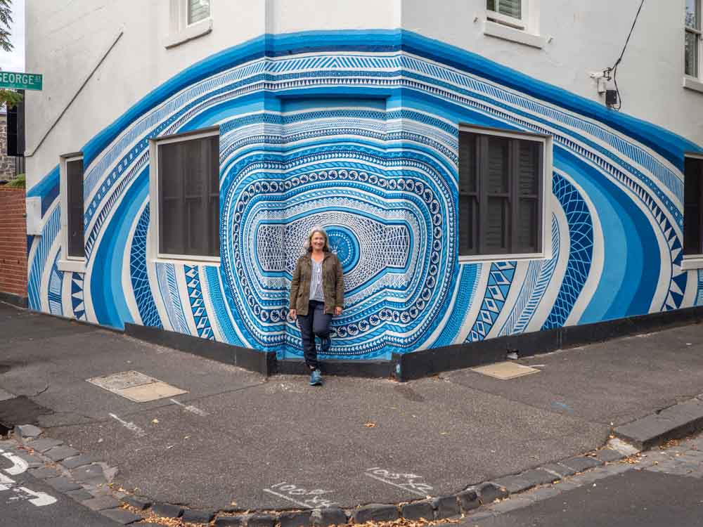 Mural in Melbourne's Fitzroy. blue painting with woman standing in front