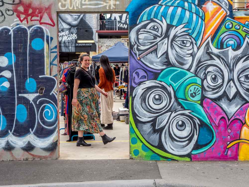 Graffiti in Fitzroy Market with woman in doorway