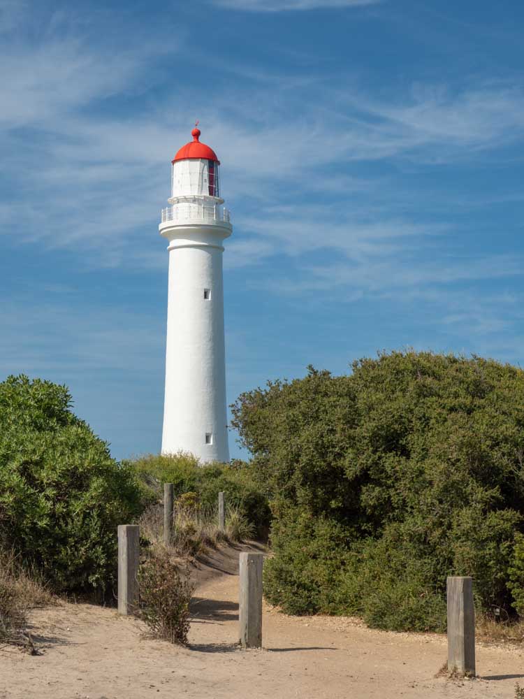 Split Point Lighthouse on the Great Ocean Road. White lighthouse with red top and trees