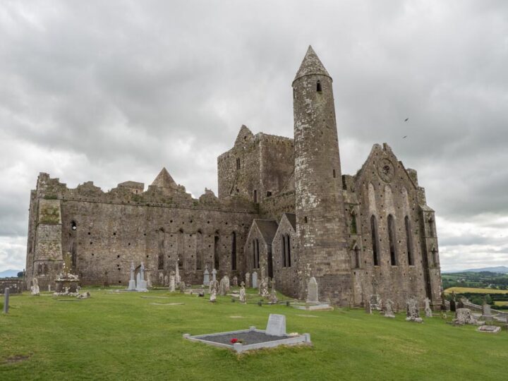 Ireland by Car: Rock of Cashel. Stone castle ruin with gravestones