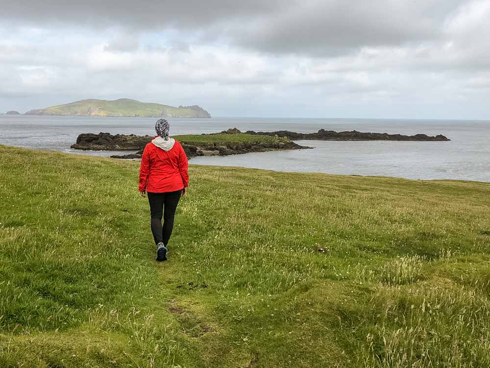 Ireland trip: Great Blasket Island Dingle. Woman in red hiking a cliff