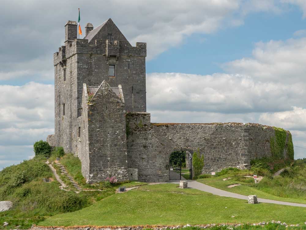 Ireland road trip: Dunguire castle Galway Bay. Castle with green grass and clouds
