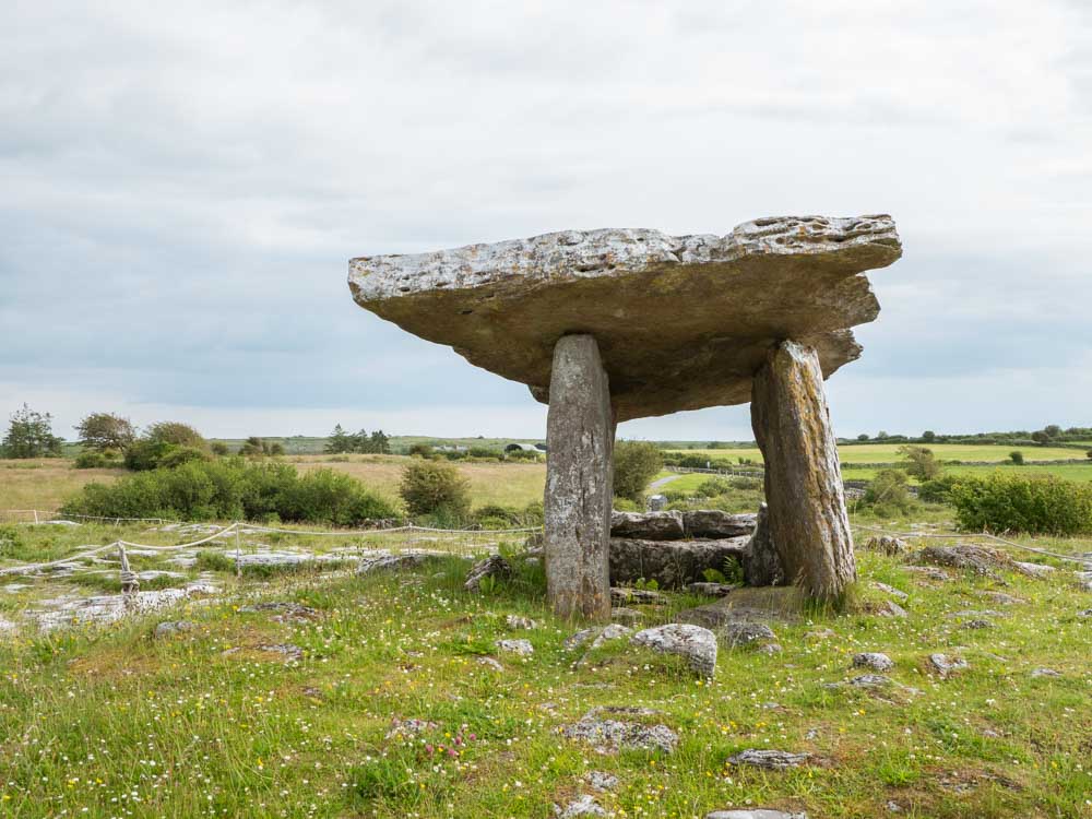 Ireland itinerary the Burren Poulnabrone Dolmen. Burial stones on green landscape