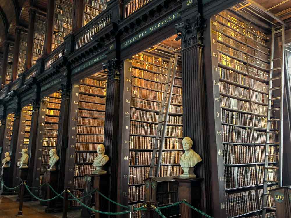 Dublin Trinity College Long Room library. Shelves of books and statues