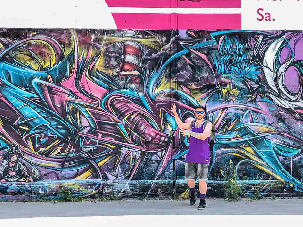 Alternative Berlin street art tour. tour guide and purple graffiti