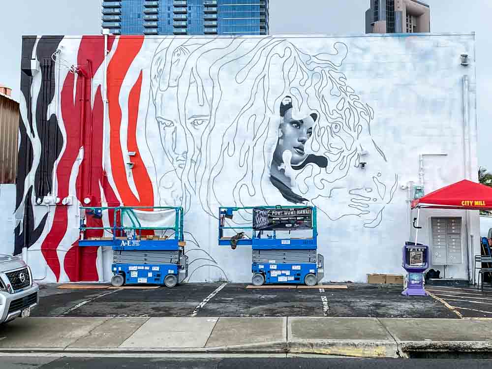 Tristan and Matt Eaton Kakaako mural in-progress. mural on building with construction equipment