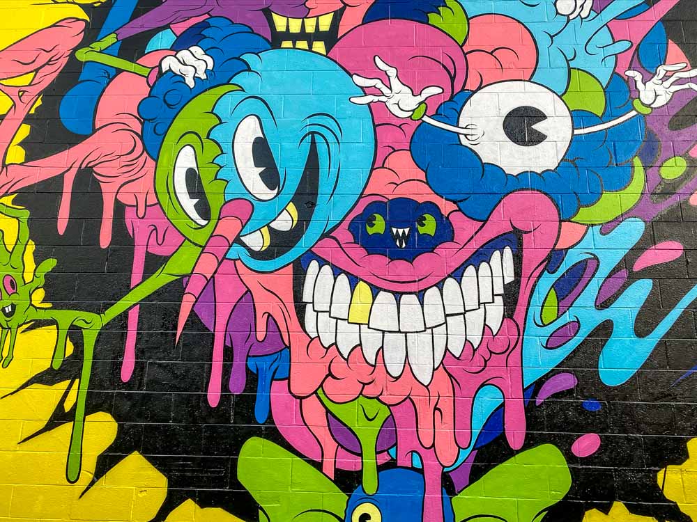 Alex Pardee monster mural on Lana Lane Honolulu. Pink and blue smiling creatures