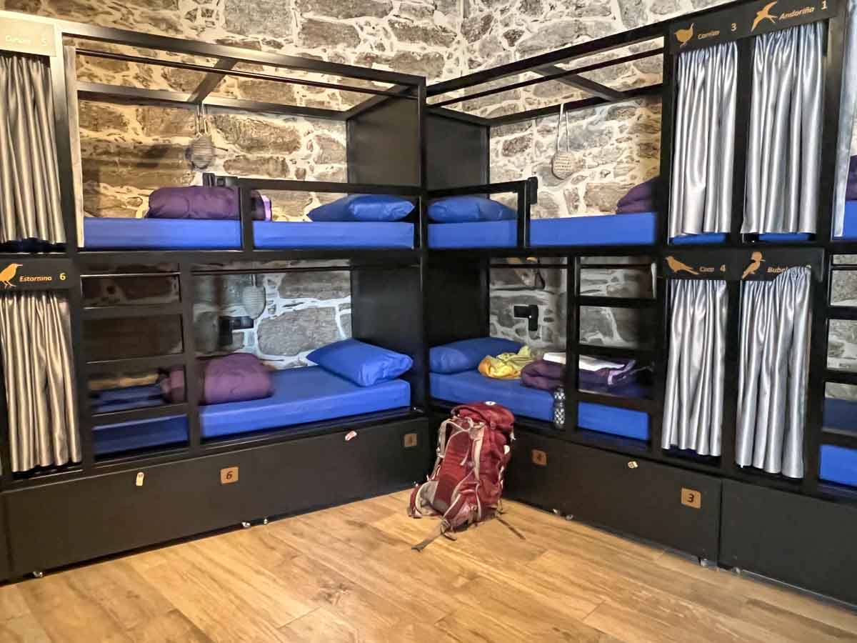 Camino de Santiago albergue in Vilar de Cas with bunkbeds and a backpack